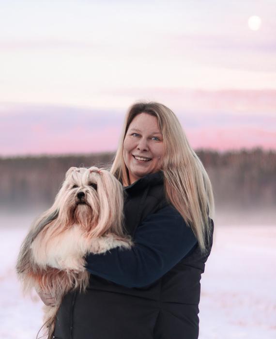 Janika Kekki talvisessa maisemassa koira sylissään